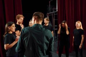 trabalhando juntos. grupo de atores em roupas de cor escura no ensaio no teatro foto