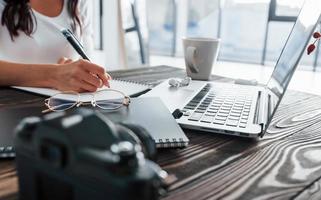 visão aproximada da jovem freelancer que trabalha dentro de casa no escritório durante o dia foto