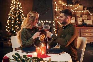 bebe vinho. jovem casal adorável tem jantar romântico juntos dentro de casa foto