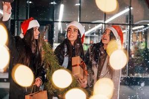 detém abeto. três mulheres alegres passam as férias de natal juntas ao ar livre. concepção de ano novo foto