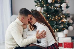 proximidade das pessoas. jovem casal romântico comemora o ano novo juntos dentro de casa foto