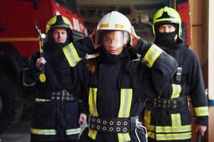 grupo de bombeiros em uniforme de proteção que está na estação foto