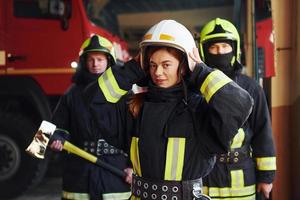 grupo de bombeiros em uniforme de proteção que está na estação foto