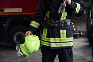 bombeiro masculino em uniforme de proteção em pé perto do caminhão foto