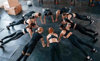 exercício de prancha. grupo de jovens esportivos tem dia crossfit dentro de casa na academia foto