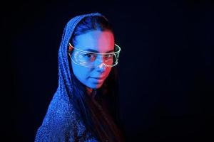 retrato de jovem que está de óculos em iluminação neon azul foto