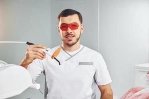 retrato de dentista profissional com equipamento que está dentro de casa foto