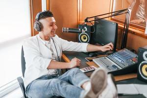 fala e usa microfone. jovem está dentro de casa no estúdio de rádio está ocupado com a transmissão foto