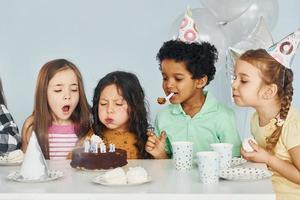 bolo de férias. as crianças comemorando a festa de aniversário dentro de casa se divertem juntas foto