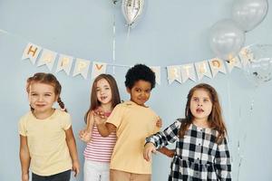 as crianças comemorando a festa de aniversário dentro de casa se divertem juntas foto