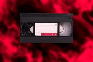 cassete de vídeo, vhs, pal secam, fundo retrô desfocado vermelho-preto. foto