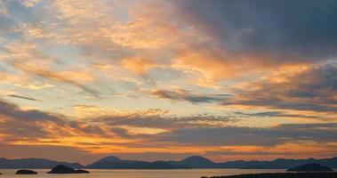 céu lindo pôr do sol com nuvens sobre o mar. silhuetas de uma série de ilhas e montanhas no horizonte. ideia para planos de fundo ou telas. pôr do sol dramático, beleza da natureza, tempo de férias foto