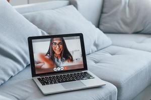 laptop que está deitado na cama. conexão online com jovem foto