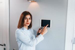 casa de controle por um toque. jovem está dentro de casa no quarto da casa inteligente durante o dia foto