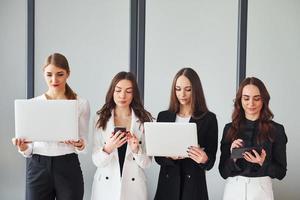 grupo de mulheres adultas que em roupas formais estão juntas no escritório foto