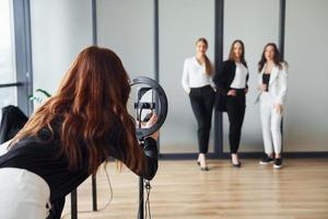 bastidores da sessão de fotos. grupo de mulheres adultas que em roupas formais estão juntas no escritório foto