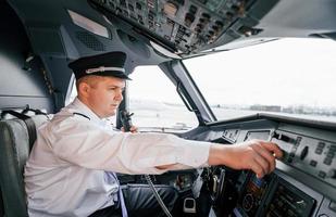 controle do voo. piloto no trabalho no avião de passageiros. preparando para decolagem foto