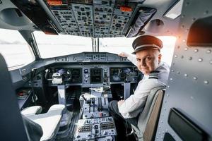 olha para trás. piloto no trabalho no avião de passageiros. preparando para decolagem foto