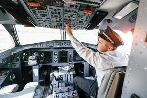 controle do voo. piloto no trabalho no avião de passageiros. preparando para decolagem foto