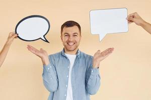 pensamentos diferentes. homem parado no estúdio com sinais vazios para o texto foto