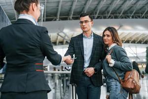 procedimento de passagem. jovem casal está no aeroporto juntos foto