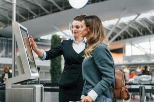 usando terminais. jovem turista feminina está no aeroporto durante o dia foto