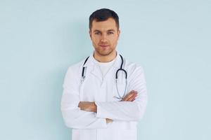 médico de uniforme em pé no estúdio foto