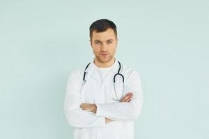 médico de uniforme em pé no estúdio foto