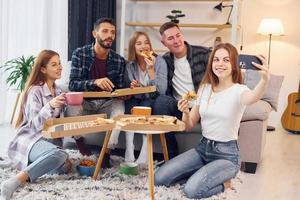 mulher fazendo selfie. grupo de amigos tem festa dentro de casa juntos foto