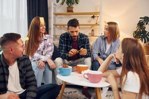 se divertindo. grupo de amigos tem festa dentro de casa juntos foto