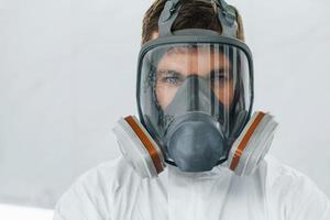 retrato de homem com máscara protetora. trabalhador de uniforme está no auto serviço foto