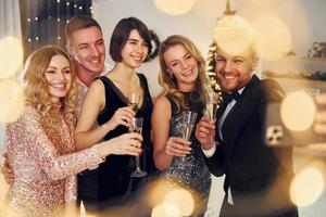 Emoções positivas. grupo de pessoas tem uma festa de ano novo dentro de casa juntos foto