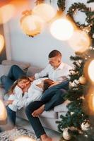 deitada na cama. família feliz comemorando feriados dentro de casa juntos foto