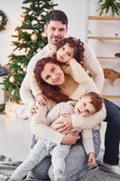 posando para a câmera. família comemorando o ano novo com seus filhos em casa foto