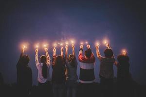 grupo de jovens amigos se divertem com fogos de artifício nas mãos juntos