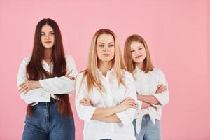 de pé juntos. jovem mãe com suas duas filhas está no estúdio foto