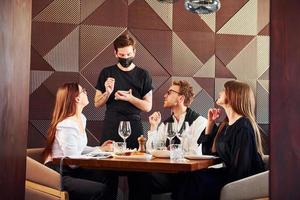 as pessoas jantam juntas. dentro do novo restaurante de luxo moderno foto