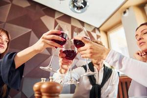 torcendo com taças de vinho. dentro do novo restaurante de luxo moderno foto