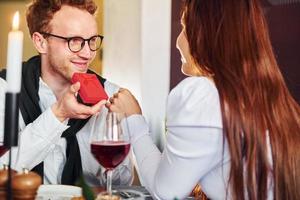 jovem faz proposta a uma mulher. dentro do novo restaurante de luxo moderno foto