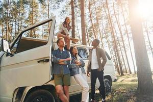 local de destino. grupo de jovens está viajando juntos na floresta durante o dia foto