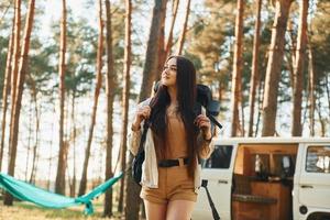 ônibus branco. mulher está viajando sozinha na floresta durante o dia no verão foto