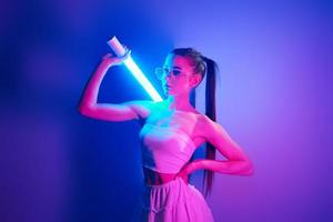 estilo futurista. jovem elegante em pé no estúdio com luz neon foto