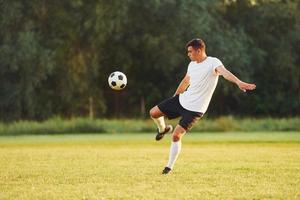 prática profissional. jovem jogador de futebol tem treinamento no campo esportivo foto