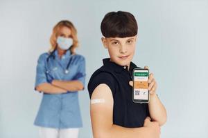 rapaz jovem. médico de uniforme fazendo vacinação para o paciente foto