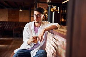 na cadeira. homem em roupas casuais, sentado no bar foto