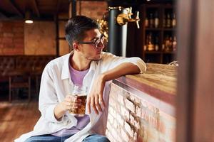 na cadeira. homem em roupas casuais, sentado no bar foto