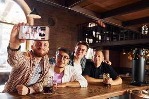 fazendo selfie. pessoas em roupas casuais sentadas no bar foto