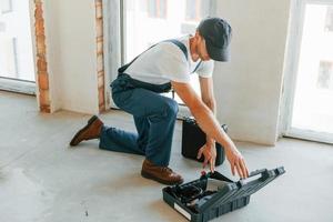 abrindo o caso. jovem trabalhando de uniforme na construção durante o dia foto