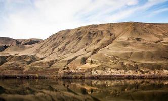 desfiladeiro deserto dourado com reflexo no rio abaixo foto