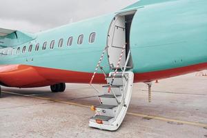 portas estão abertas. aeronaves turboélice estacionadas na pista durante o dia foto